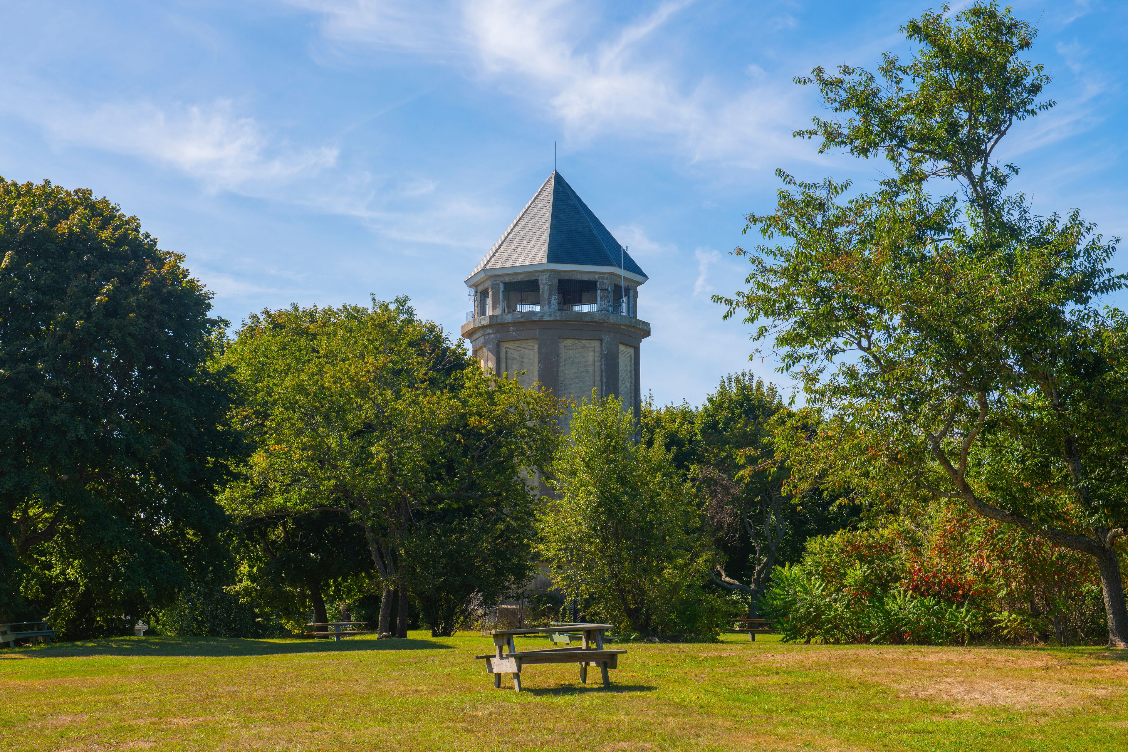 A park with a gazebo, picnic table, and a tower.
