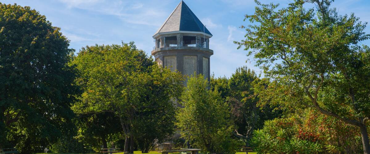 A park with a gazebo, picnic table, and a tower.