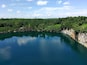 Un lago tranquillo circondato da una fitta foresta e da imponenti scogliere rocciose.