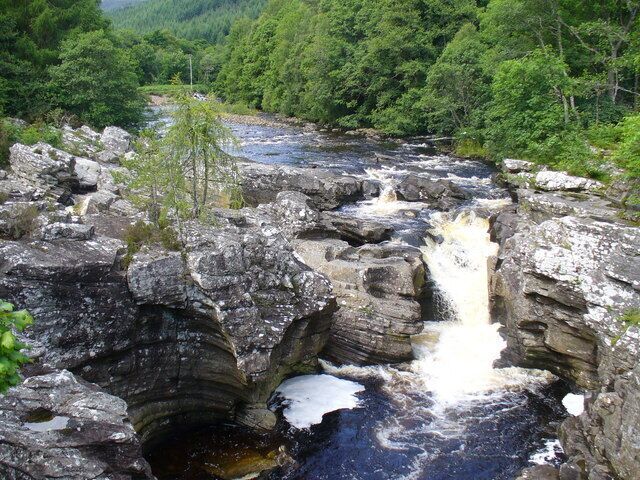 A rocky waterfall surrounded by dense forest.