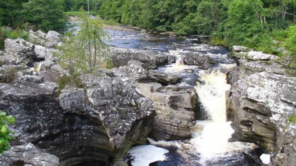 A rocky waterfall surrounded by dense forest.