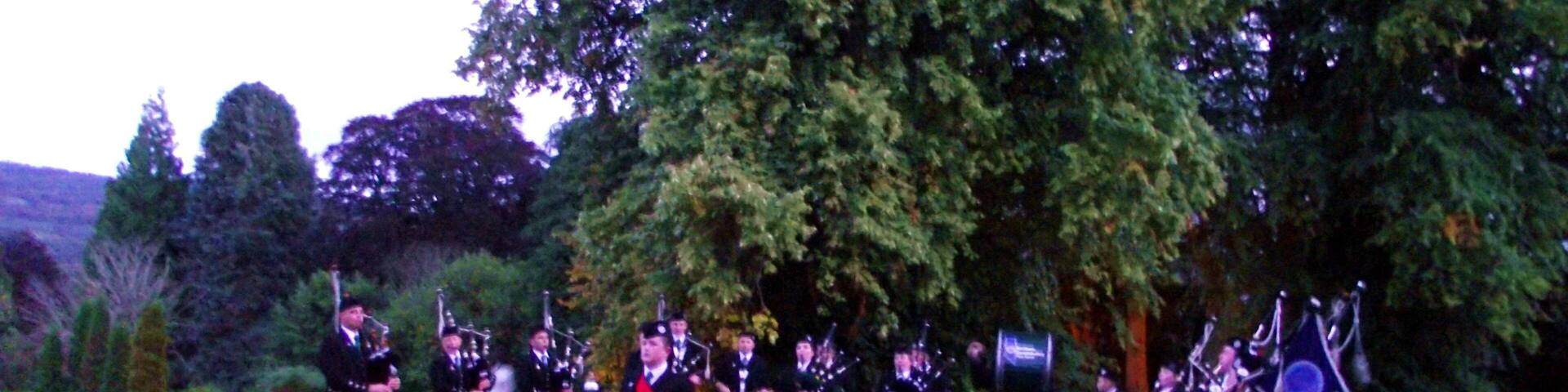 Band forms a semi circle on the lawn in front of the Castle in twilight. BAND AT ACHNAGAIRN CASTLE - The band were delighted to be asked to perform at the International Social Travel Summit Gala Dinner tonight at the beautiful Achnagairn Castle near inverness. The summit was attended by over 120 delegates from a considerable number of countries, and we were more than happy to entertain them outside this historic and beautiful building. Our slot was between the delegates arrival and their going into dinner. Pipe Major Steve Spencer was playing out on the front lawn in the gloaming - and the guests lapped up the "solo piper" performance - only for them to whoop with delight when the surprise appeared, the full Band marching out from the side of the Castle to join the Pipie on the lawn. Despite work and health issues at short notice, which saw the number of pipers diminished somewhat, we were still able to field ELEVEN pipers, SEVEN snare drummer, a bass and a Drum Major (20 in total). The delegates were obviously enjoying the performance when, all too soon, it was time for the Band to conclude and march off, so the guests could go to dine. Despite the failing light, hopefully my photographs will give a hint of the occasion - being an international event, VisitScotland anticipate many far better photos than mine all over the internet before long!