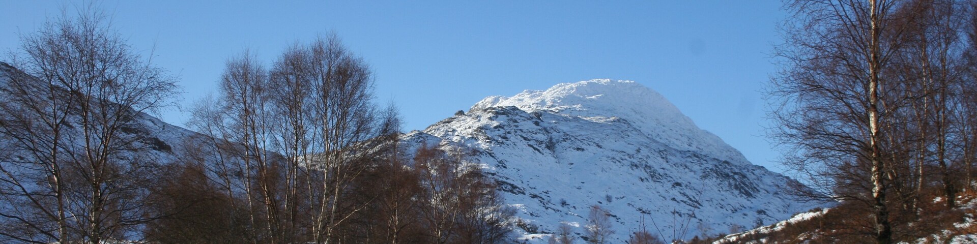 Montanha coberta de neve com um céu azul límpido.