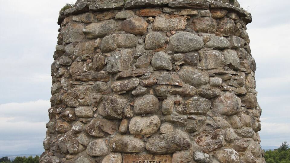 A stone monument with a plaque commemorating the Battle of Culloden.