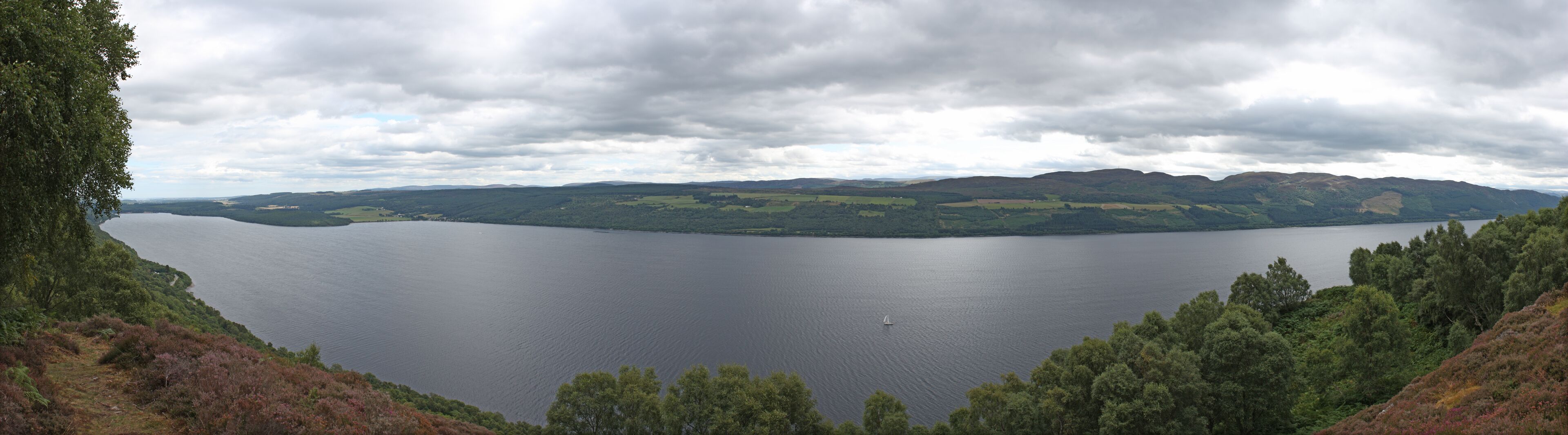 A lake surrounded by hills and dense forests.