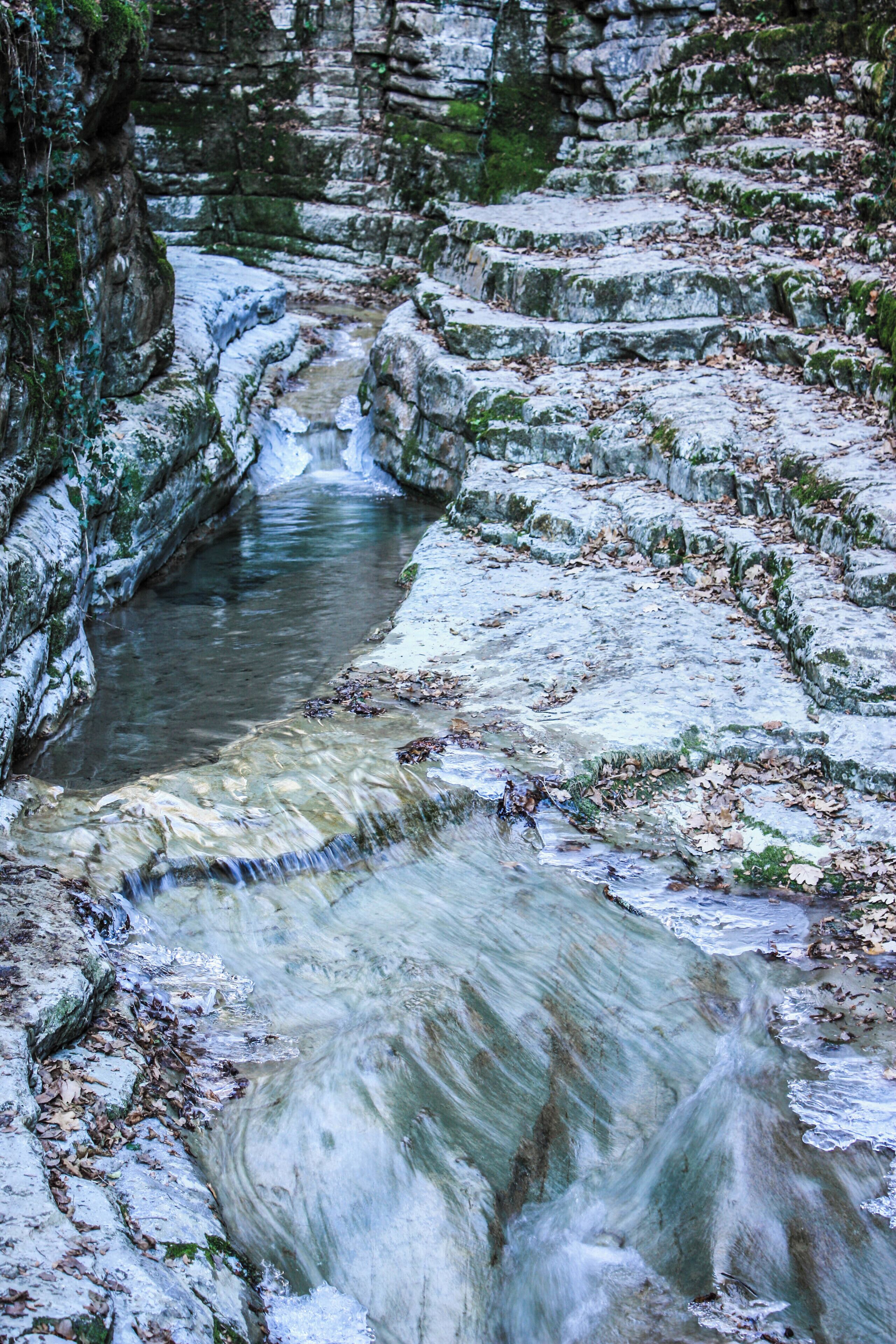 A cascading water feature with a rocky, terraced landscape.