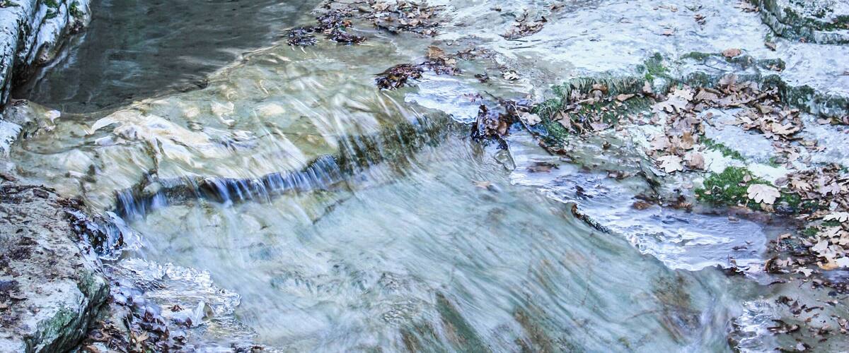 A cascading water feature with a rocky, terraced landscape.