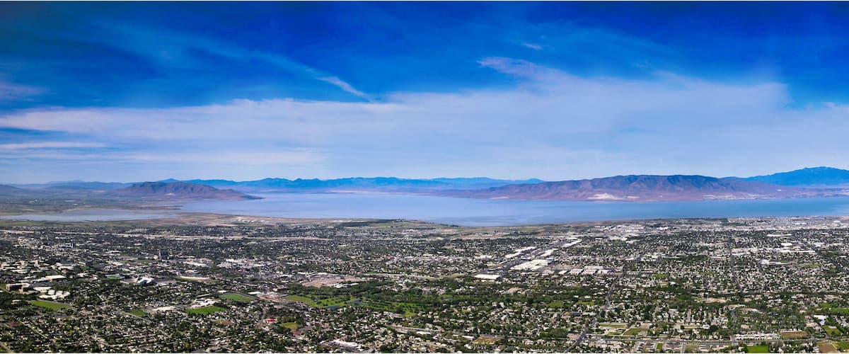 A coastal city with mountains in the background and a large body of water.