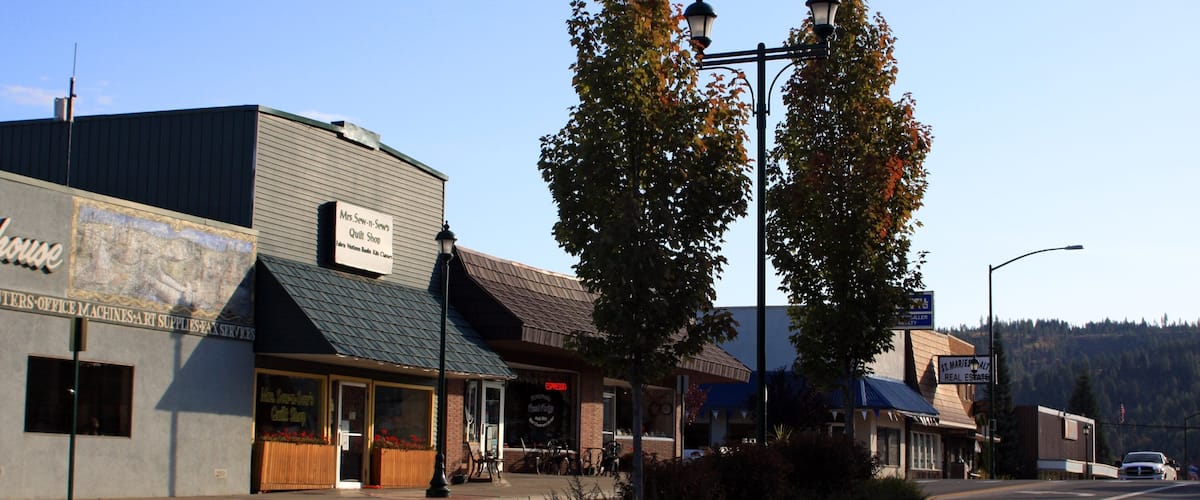 A street with a quilt shop, a hardware store, and a restaurant.