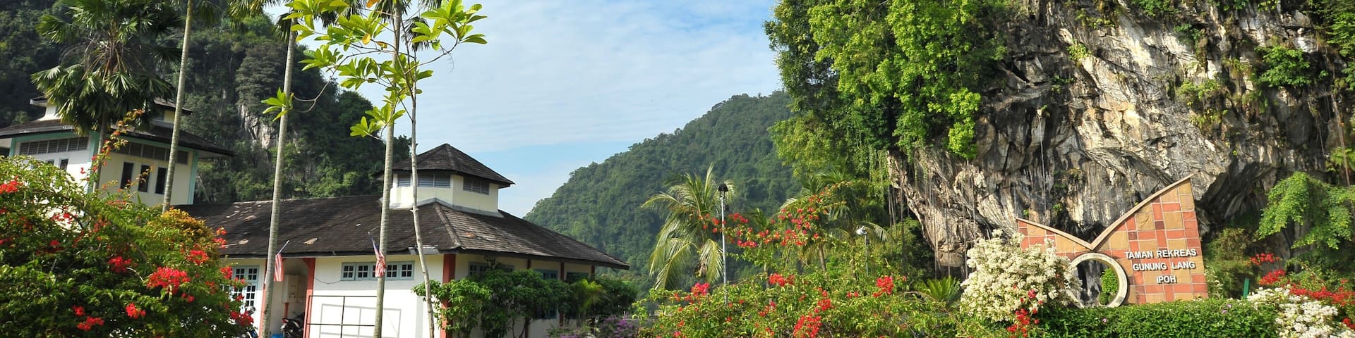 A mountainous landscape with a sign reading "TAMAN REKREAS GUNUNG LANG IPOH".
