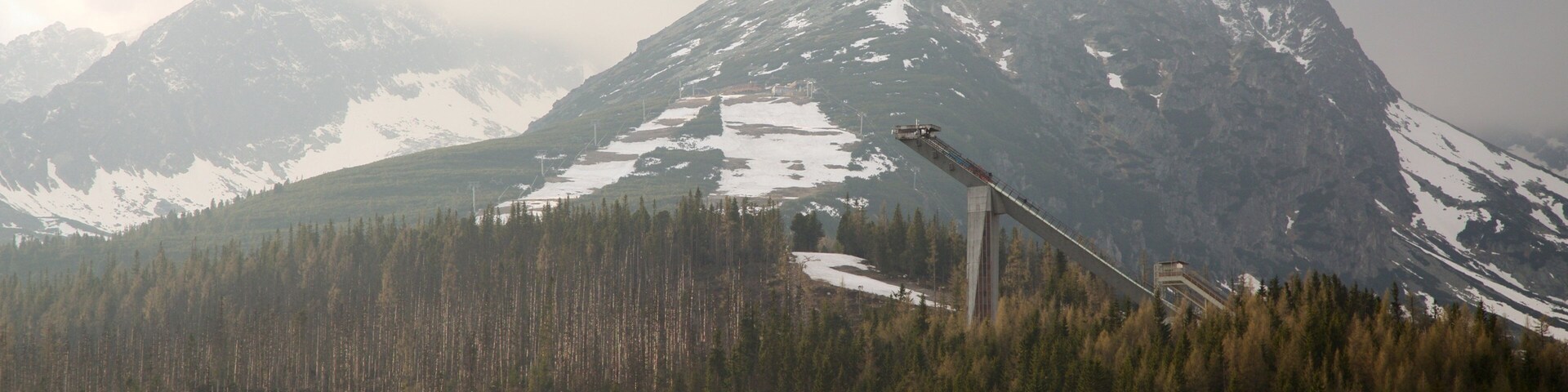 A mountain with a ski lift and a forested valley.