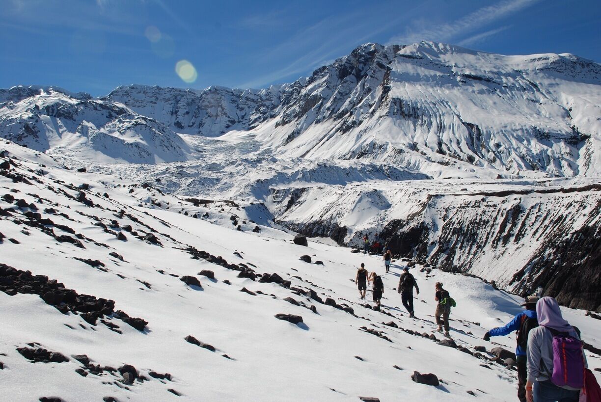 Eine verschneite Berglandschaft mit Wanderern.
