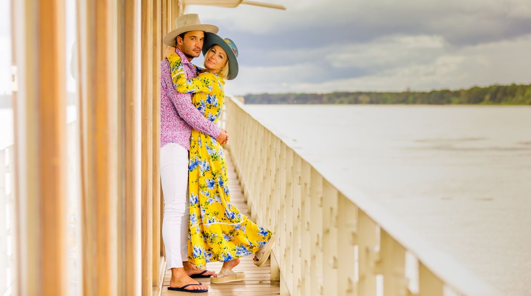 Couple posing for the camera overlooking the Amazon River aboard a river boat, Peru, South America