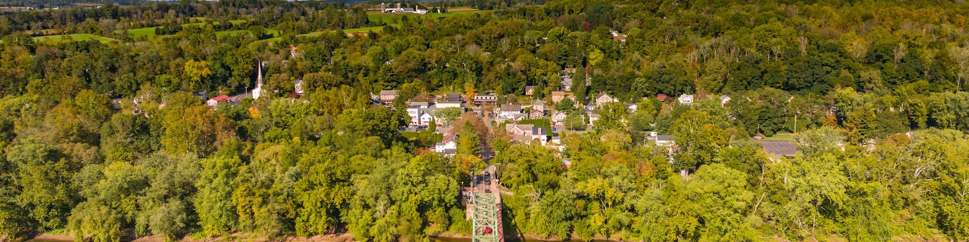 Uma ponte sobre o rio, com uma cidade ao fundo.