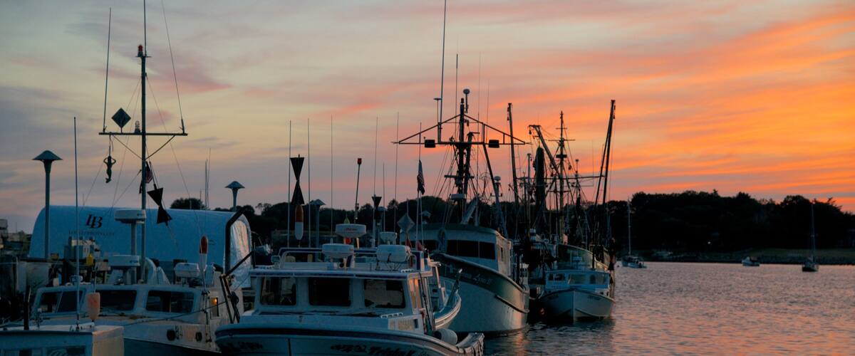 Stonington montrant baie ou port et coucher de soleil