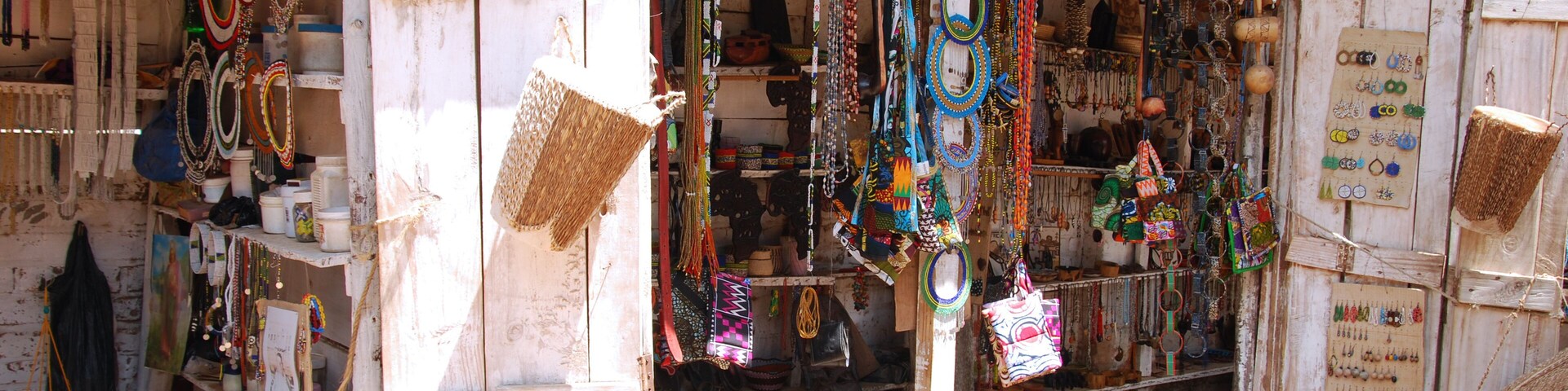 Uma banca de mercado com diversos itens de joalharia, incluindo colares, pulseiras e bangles.