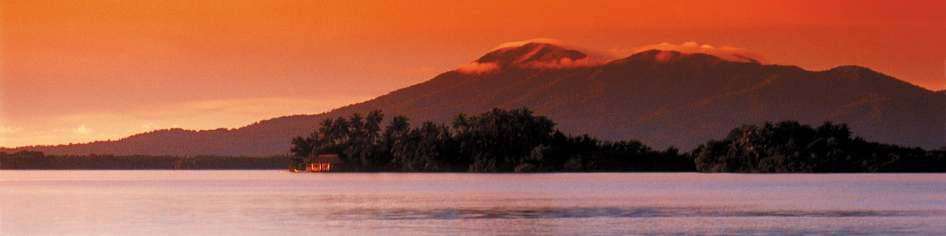 Islas Salomón ofreciendo montañas, una puesta de sol y vistas generales de la costa