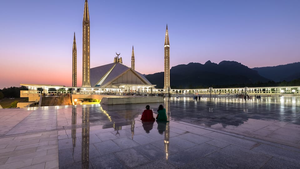 A mosque with four minarets and a large courtyard.