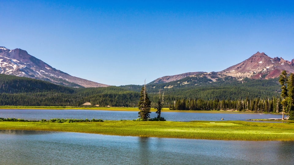 A lake surrounded by mountains and evergreen trees.
