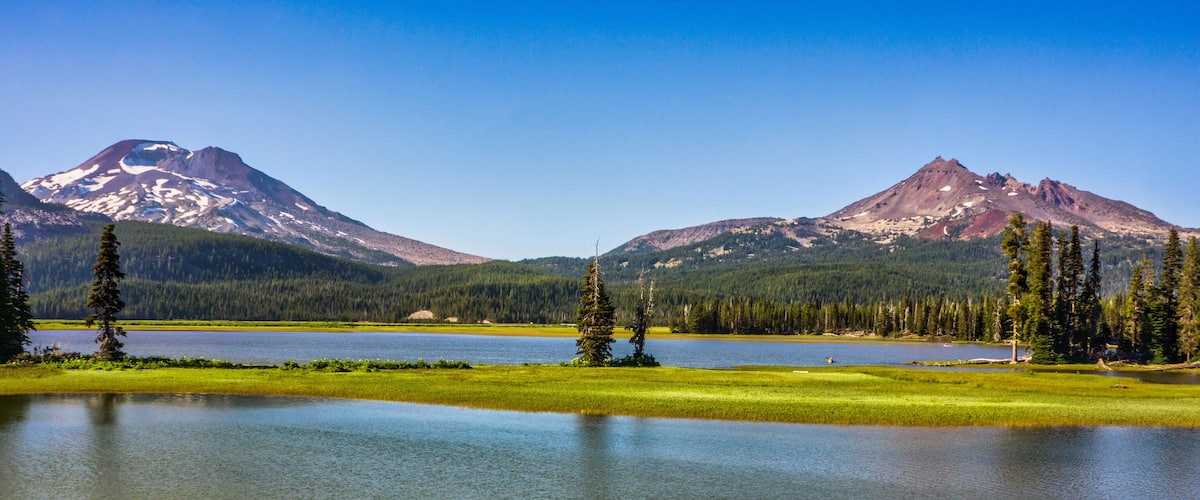 A lake surrounded by mountains and evergreen trees.