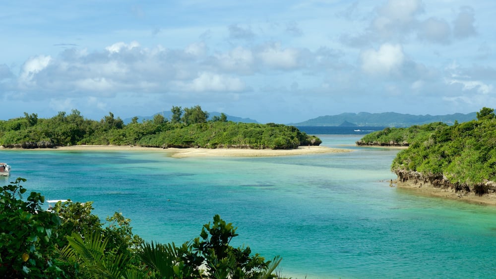 Une île tropicale aux eaux turquoise et limpides, aux plages de sable fin et à la végétation luxuriante.