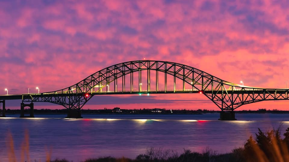 A bridge at sunset with a pink sky.