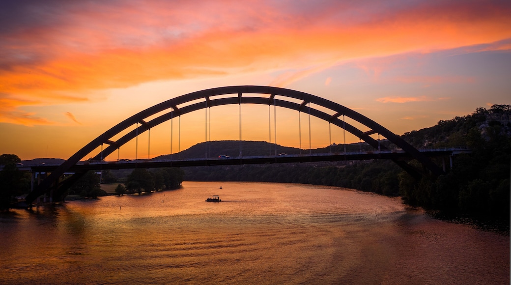 Austin, Texas - Colorful sunset over the Pennybacker Bridge (360 Bridge) spanning Lake Austin. Scenic view of the iconic arch bridge, Texas Hill Country cliffs, and Capital of Texas Highway.