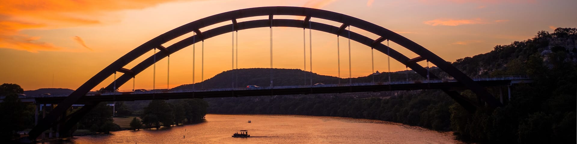Austin, Texas - Colorful sunset over the Pennybacker Bridge (360 Bridge) spanning Lake Austin. Scenic view of the iconic arch bridge, Texas Hill Country cliffs, and Capital of Texas Highway.