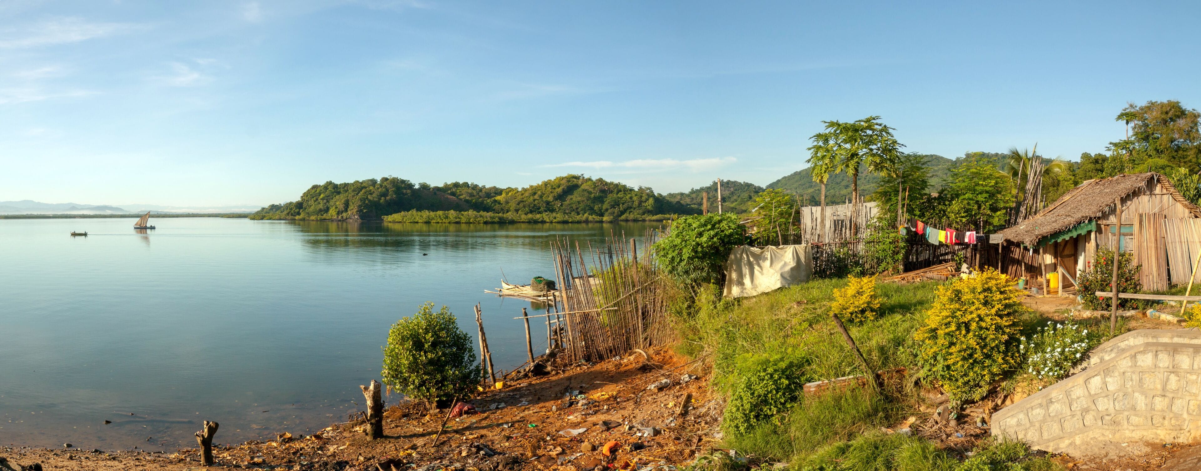 Traditional house overlooking the Indian ocean near Port Ankify, Ambanja district, northern Madagascar; in the distance two boats sail out