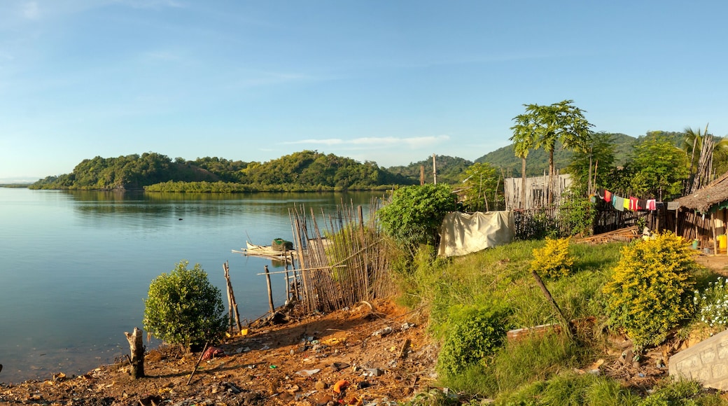 Traditional house overlooking the Indian ocean near Port Ankify, Ambanja district, northern Madagascar; in the distance two boats sail out