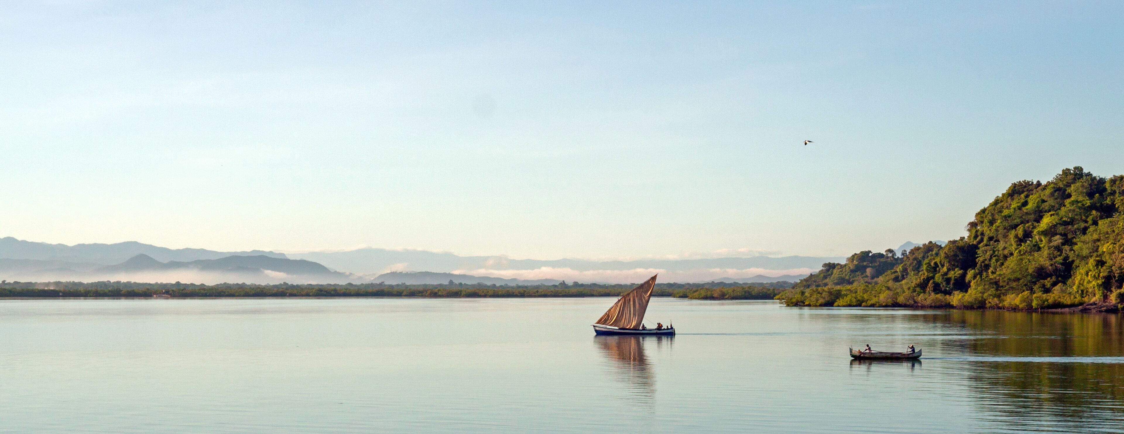 Nosy Be, Madagascar: traditional sailing boat and canoe sail out on the Indian Ocean from Port Ankify, Ambanja district, Northern Madagascar. 