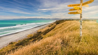 Distance and direction signpost on a beautiful, sunny beach. McCracken's Rest, Southland, New Zealand.