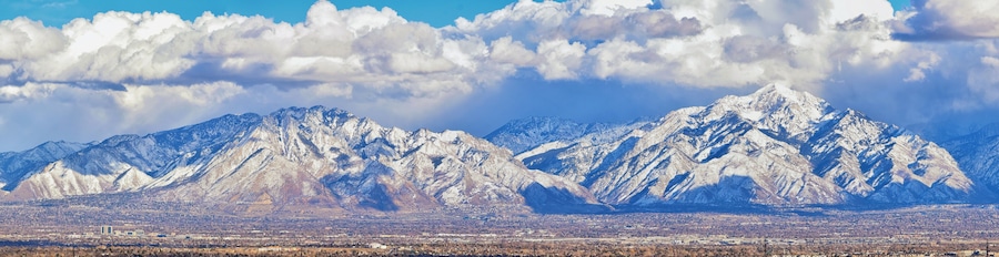 Winter Panoramic view of Snow capped Wasatch Front Rocky Mountains, Great Salt Lake Valley and Cloudscape from the Bacchus Highway. Utah, USA.