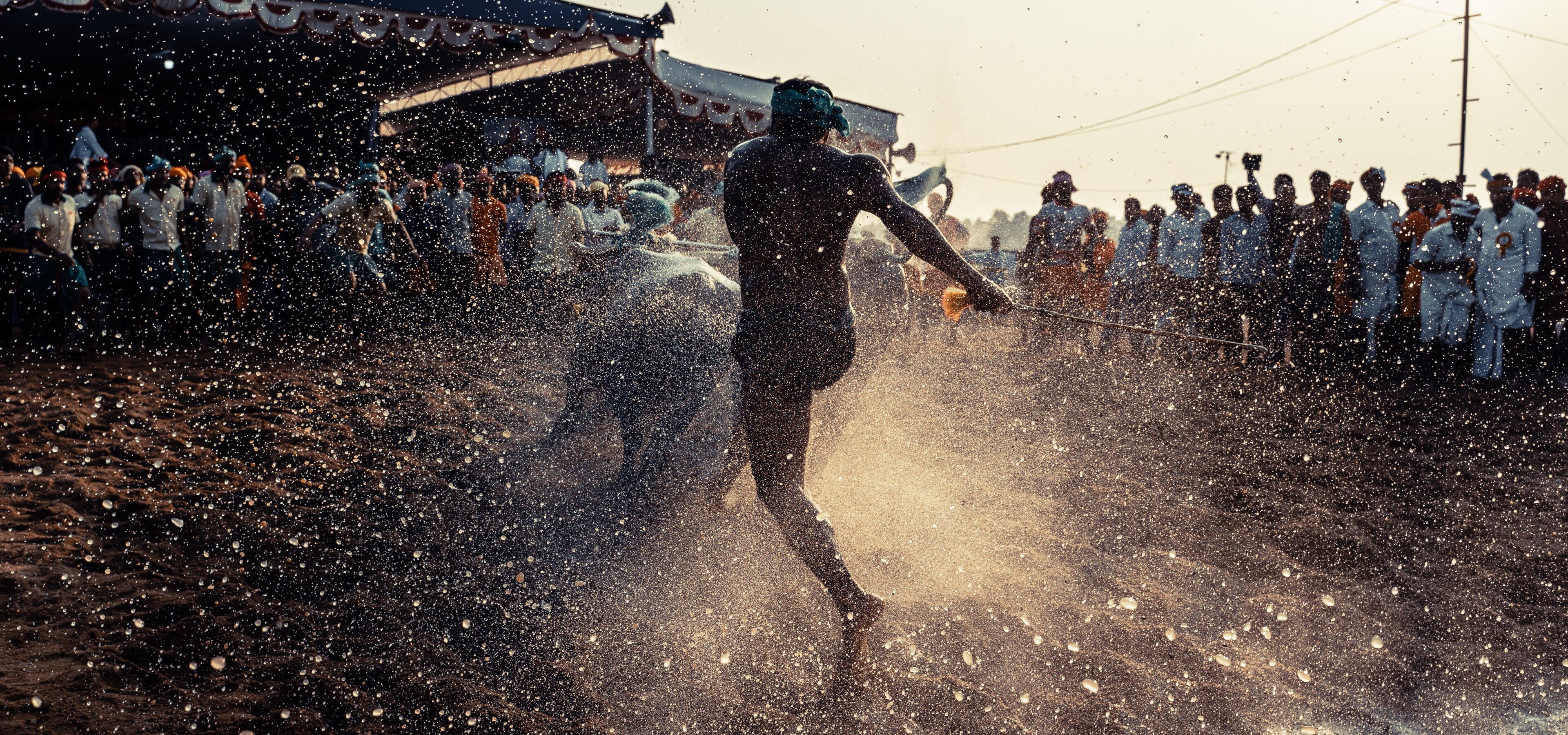 A person running through a crowd with water being sprayed.