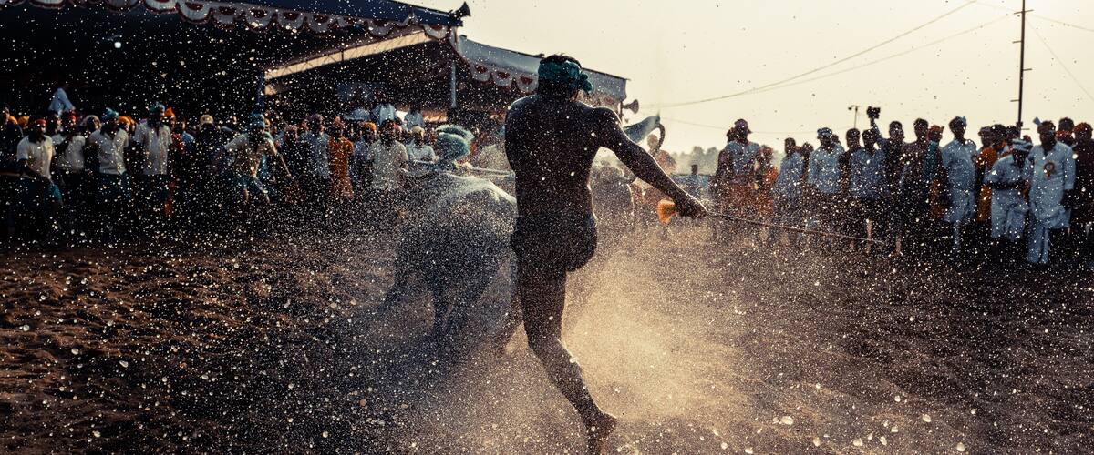 A person running through a crowd with water being sprayed.