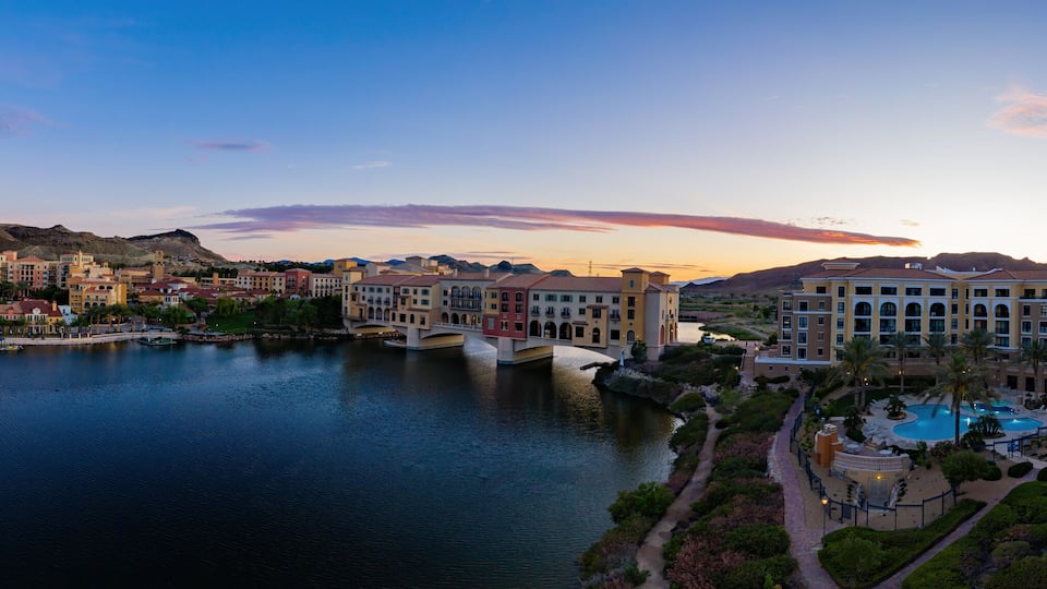 A coastal cityscape with a river, a bridge, and a large hotel complex.