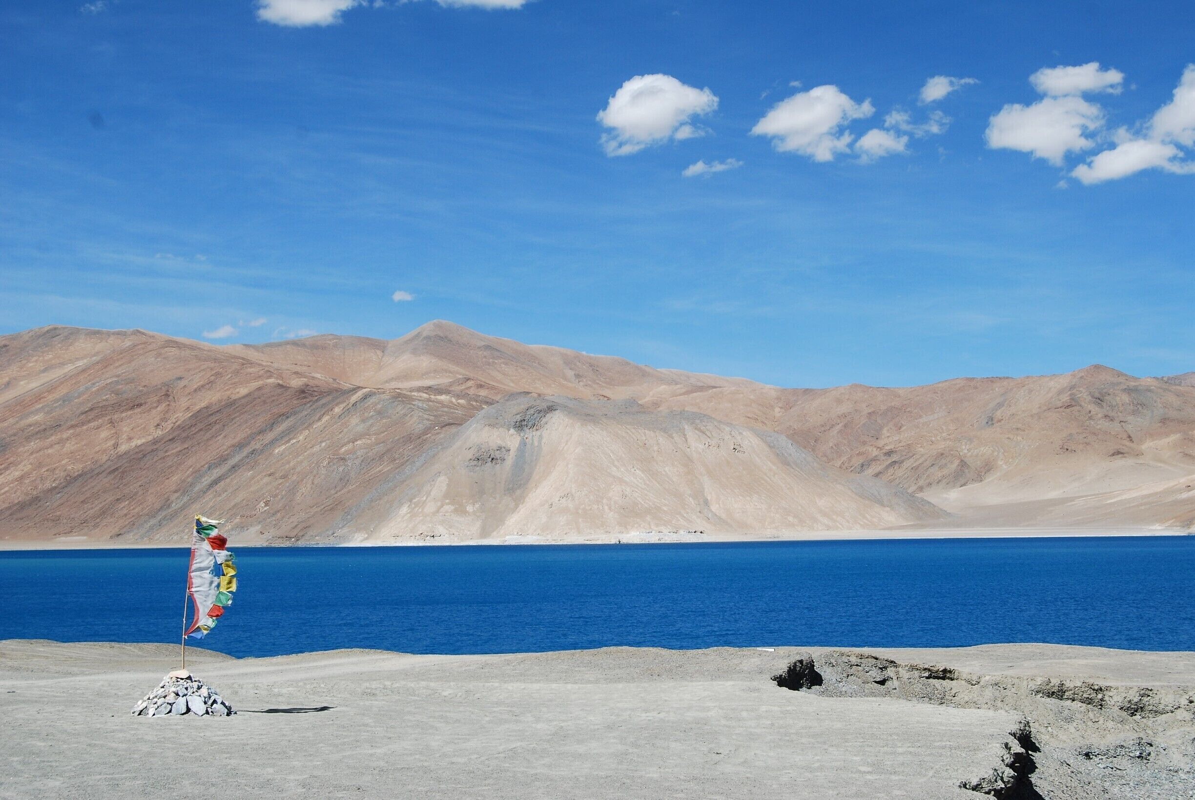 A view astride Pangong Tso (Lake in ladakhi language, India.

The place is magical, outlandish to some extent. The salt water lake is at an altitude of 14000 ft, one of the highest lakes. Its 90 km long and the widh ranges from 2 to 5 km at places. With no water life, the depth goes upto 200 metres.

One can see the magic as the blue exudes different hues throughout the day. a popular destination for hikers, bikers and travellers. The lake freezez from October to March. best time to go is June to Sep. 