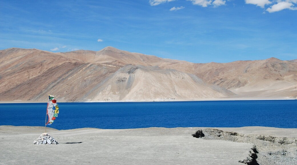 A view astride Pangong Tso (Lake in ladakhi language, India.
The place is magical, outlandish to some extent. The salt water lake is at an altitude of 14000 ft, one of the highest lakes. Its 90 km long and the widh ranges from 2 to 5 km at places. With no water life, the depth goes upto 200 metres.
One can see the magic as the blue exudes different hues throughout the day. a popular destination for hikers, bikers and travellers. The lake freezez from October to March. best time to go is June to Sep.