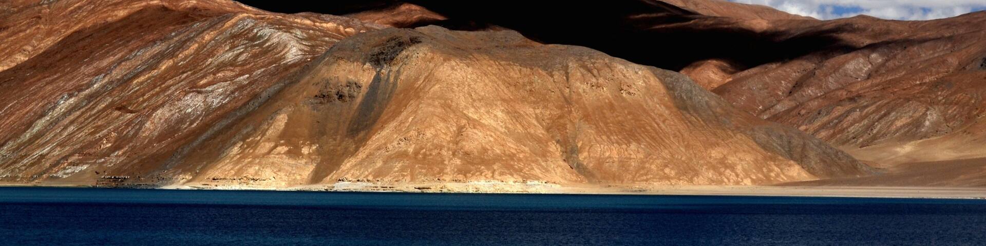 Leh que incluye montañas y un lago o espejo de agua
