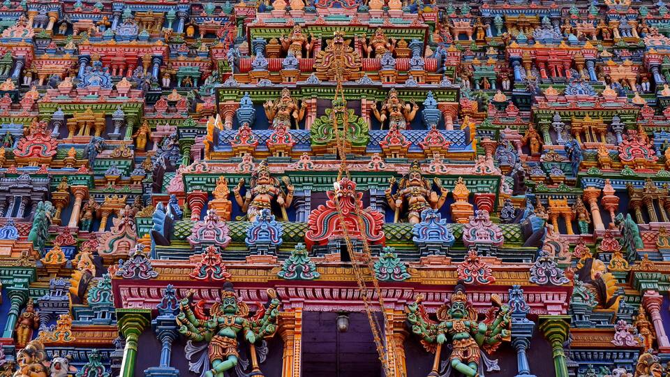 A colorful temple facade with intricate carvings and statues.