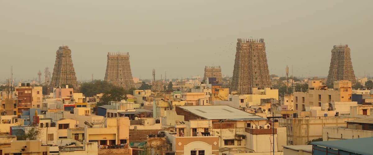 A densely populated urban area with numerous buildings and several large, ornate towers.