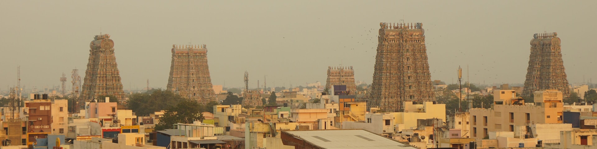 A densely populated urban area with numerous buildings and several large, ornate towers.