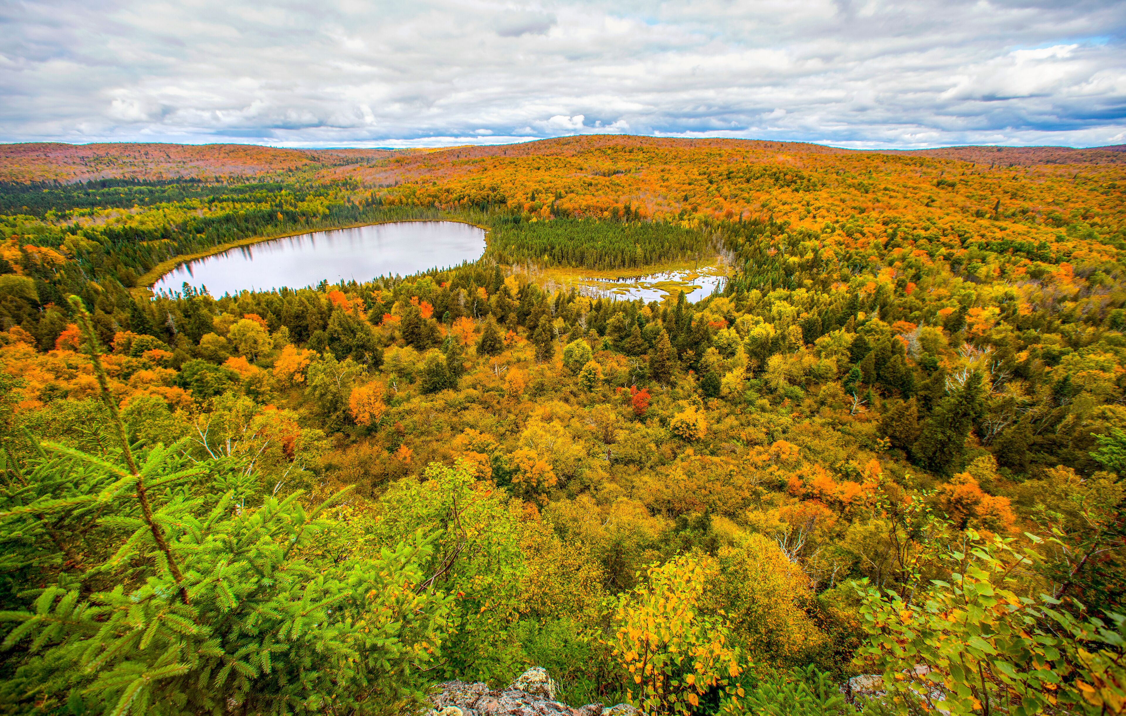 A lake surrounded by autumn-colored trees and hills.