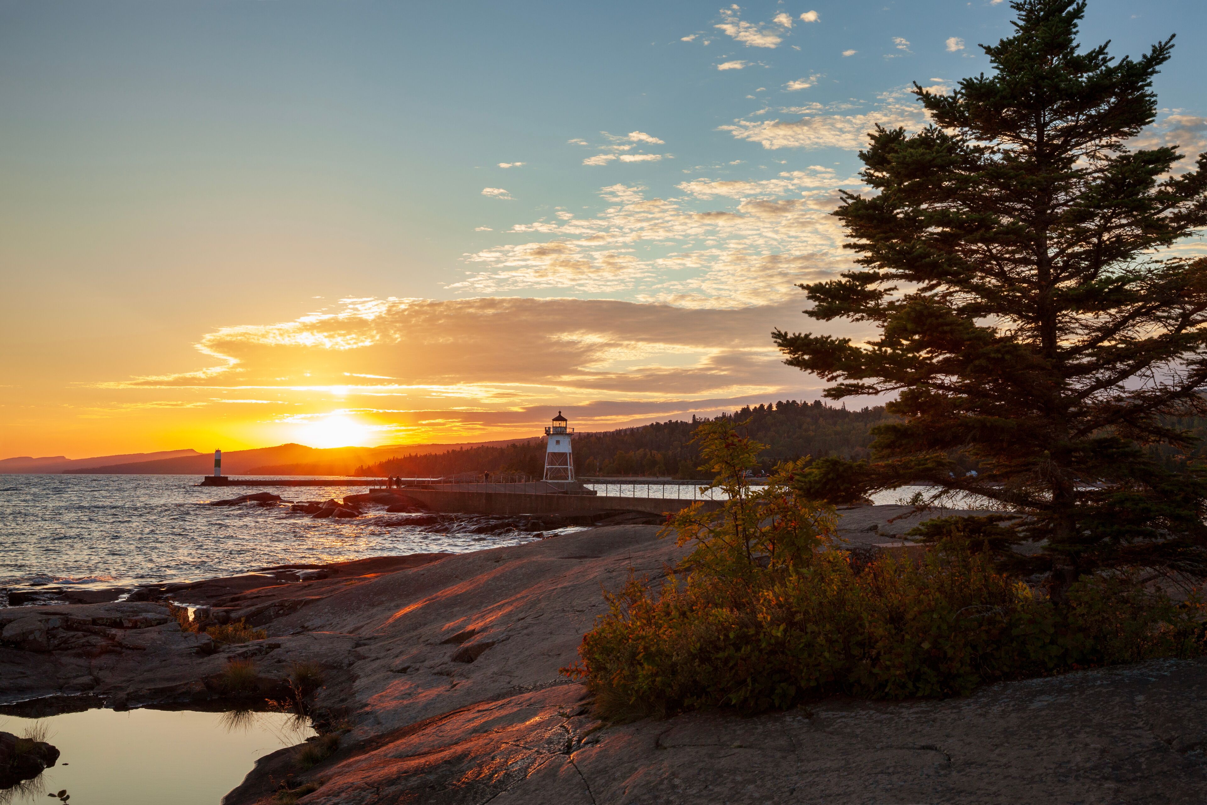 Sunset at Artist's Point with the lighthouse and Lake Superior in Grand Marais Minnesota