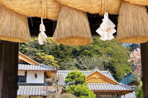 Un bâtiment traditionnel japonais, doté d’un toit de chaume et de poutres en bois.