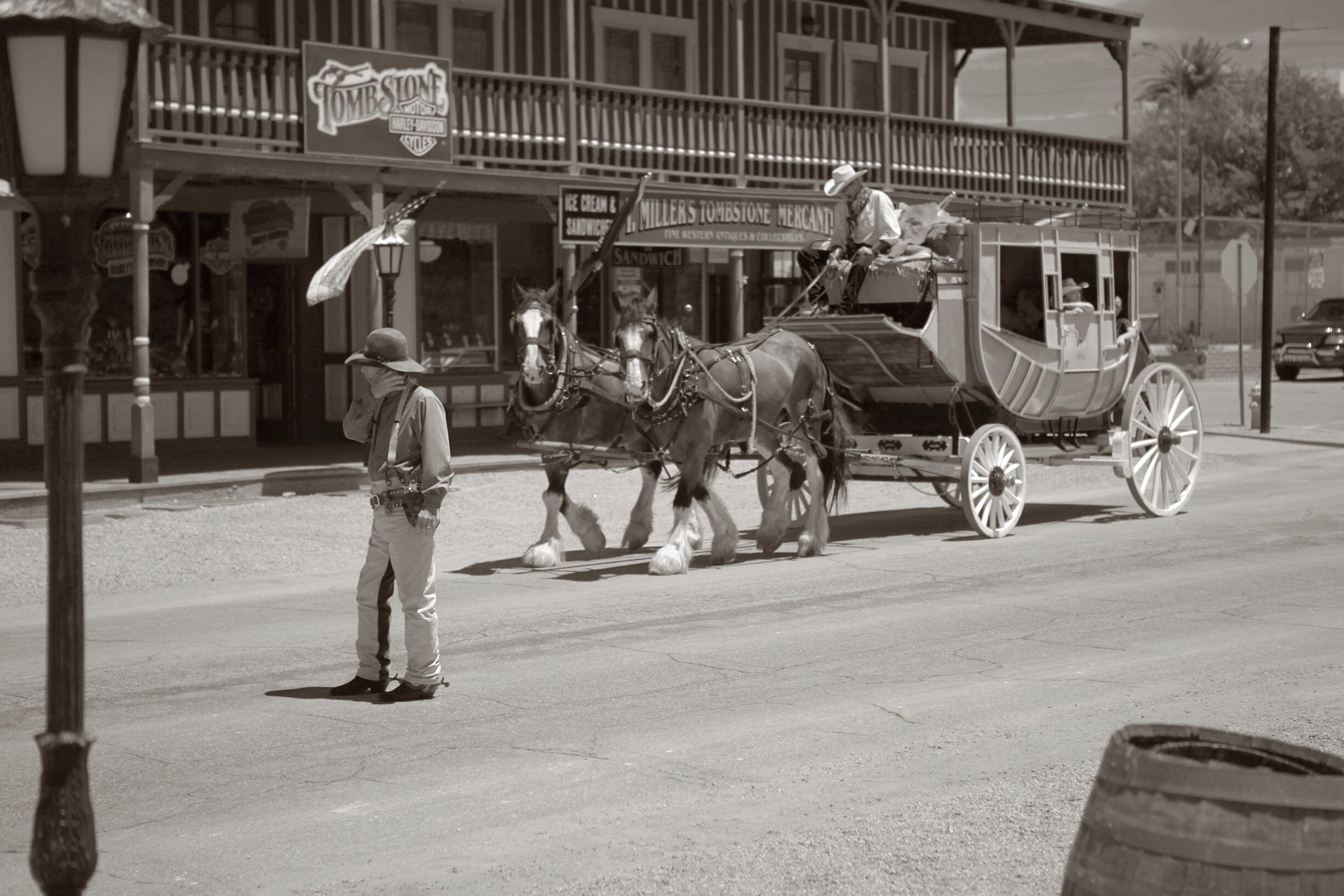 Een paard en wagen rijden over een straat, met een bordje voor 'Miller's Tombstone Mercantile'.