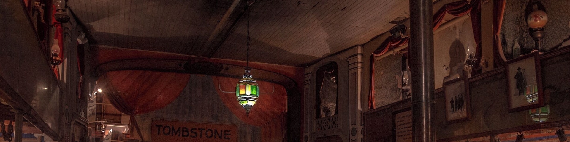 The Birdcage Theater is one of Tombstone's most authentic attractions and one of the West's most famous landmarks. Legend has it 26 people were killed in the Bird Cage during it reputed 8 years as one of the wildest and meanest places in Tombstone. Over 120 bullet holes remain in the building. The ladies of the night, plied their trade in cribs suspended from the ceiling in the building. 14 cribs lined the sides of the gambling hall, 7 on each side of the room. The ladies would pull the drapes to entertain their clients.
Within these walls once drank and played the likes of Wyatt Earp, Bat Masterson, and members of the Cowboy faction, and Doc Holliday, who dealt faro in the gambling parlor. On one occasion, while Doc was dealing, one of his hated rivals, Johnny Ringo, passed by the table. Doc then murmured, "Care to buck the tiger, Johnny? It's the gustiest game in town."
Upon hearing this, a drunken Ringo wheeled around, removed his bandana and said to Holliday,
"Care to grab to the other end of this bandanna? This is the deadliest game in town."
In those days when two men grabbed the opposite ends of a bandanna, they would then fire at each other at point-blank range, generally with both men winding up dead.
Undaunted, Doc simply stood smiling, ready to accept the challenge, but ready to use knives, rather than guns.
Curly Bill Brocius then interceded, grabbing Ringo and yelling, "Hell, Doc, heâs drunk!â
Doc, who had also been drinking, like usual, answered, "Brocius, I drink more by 10:00 a.m. than he can all day." Doc then turned and walked away.
One of its most famous distinctions was one of the longest running games of poker ever played. Seating seven players plus a dealer, the minimum buy-in was $1,000.00 and was played around the clock for, 8 years 5 months and three days.