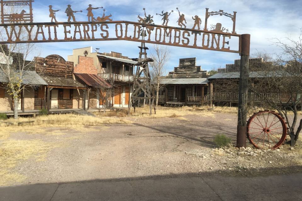 Un senyal rústic amb figures de cowboys i la inscripció 'Wyatt Earp's Old Tombstone'.