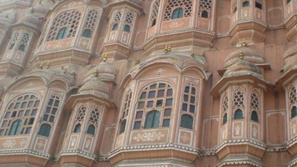 A large, ornate building with multiple arched windows and intricate architectural details.