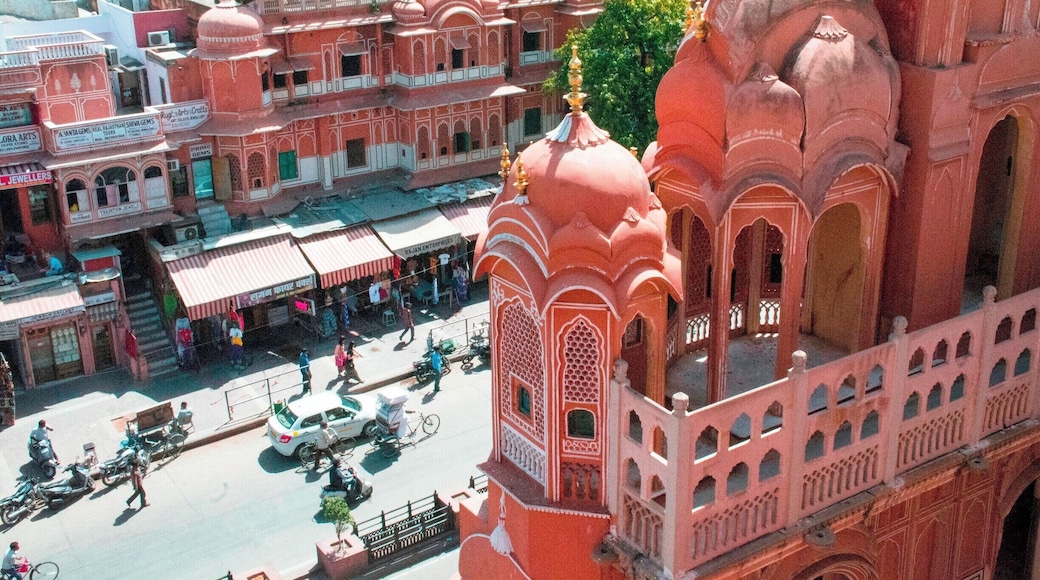 The Hawa Mahal, or "Palace of the Winds" in the foreground, was constructed in the late 18th century by the Maharaja Sawai Pratap Singh so that the ladies of royal household could watch processions on the street below without being seen from the outside.